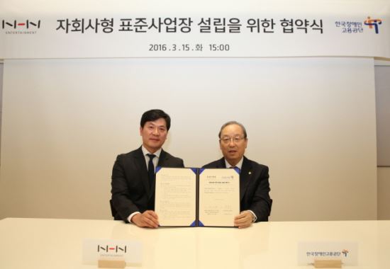 NHN엔터테인먼트 정연훈 총괄이사(왼쪽)와 한국장애인고용공단 박승규 이사장이 협약서에 사인하고 기념 촬영을 하고 있다.